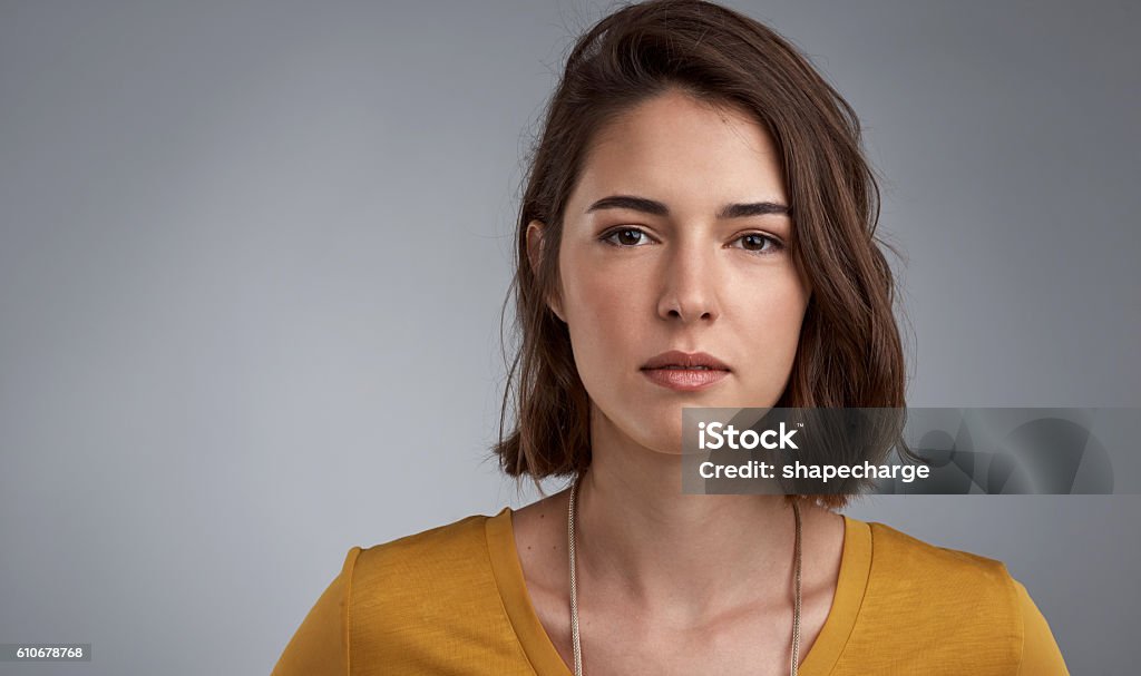 Some moments call for seriousness Studio portrait of a young woman looking serious against a gray background Women Stock Photo