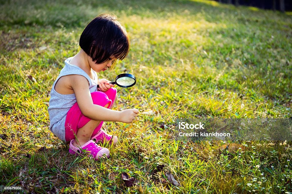 Petite fille chinoise asiatique explorant avec une loupe - Photo de Enfant libre de droits