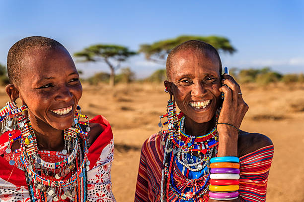 mujer de la tribu masái usando el teléfono móvil, kenia, áfrica - masai community africa indigenous culture fotografías e imágenes de stock