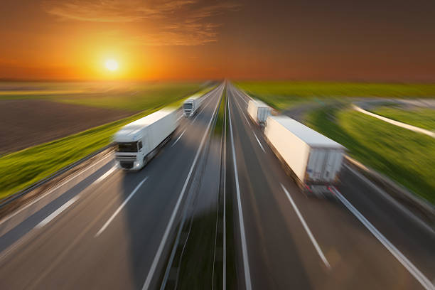 istock Reefer trucks in motion blur on empty freeway at sunset 610680978