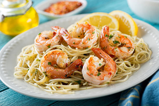 Shrimp Scampi with Spaghetti A delicious plate of shrimp scampi with spaghetti and lemon. shrimp seafood photos stock pictures, royalty-free photos & images