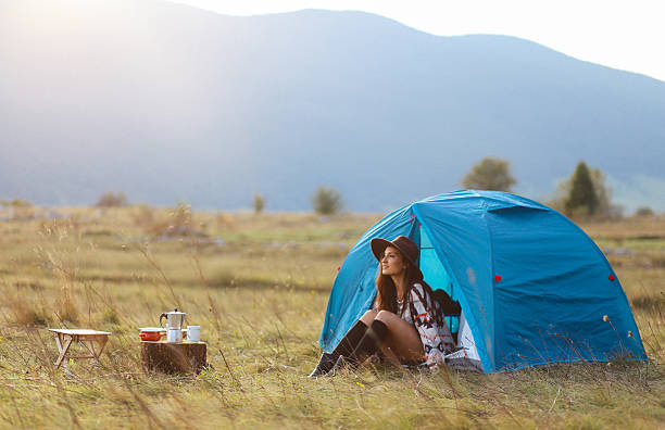 istock Young woman camping in a tent in sunset 610682328