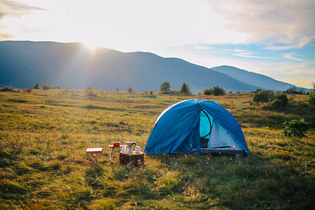 In a beautiful camping landscape, a young woman struggles with camping chores