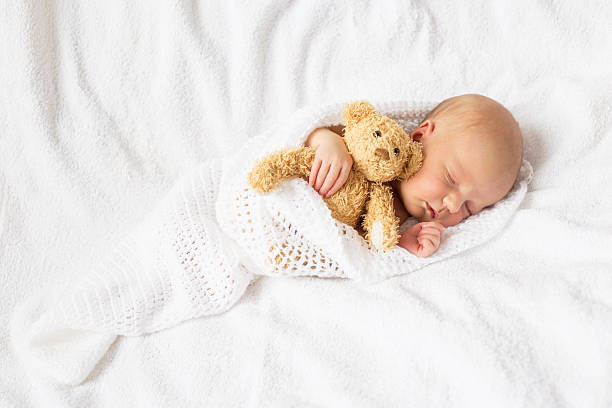 istock Newborn baby with teddy bear 610685148