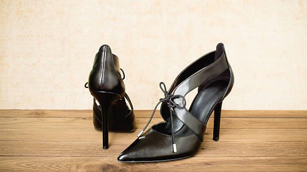 istock Black high heel shoes on wooden background 610691068