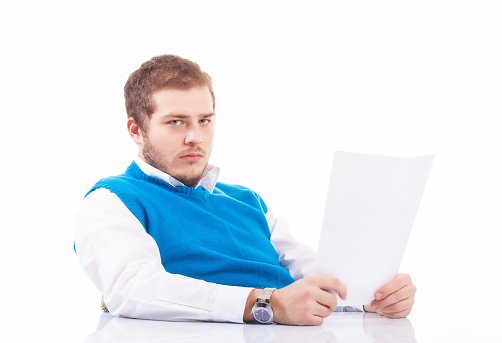 Worried young businessman holding papers, studio shot