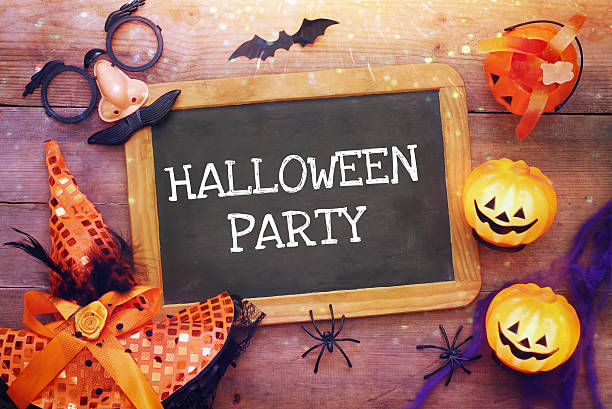 istock Pumpkins, spiders, bats and blackboard on wooden table 610692788