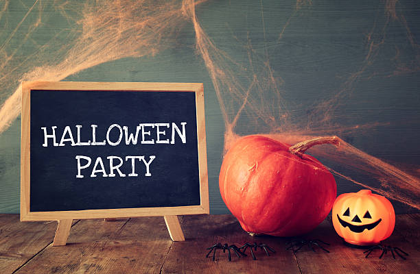 istock Cute pumpkins next to blackboard on wooden table 610693006