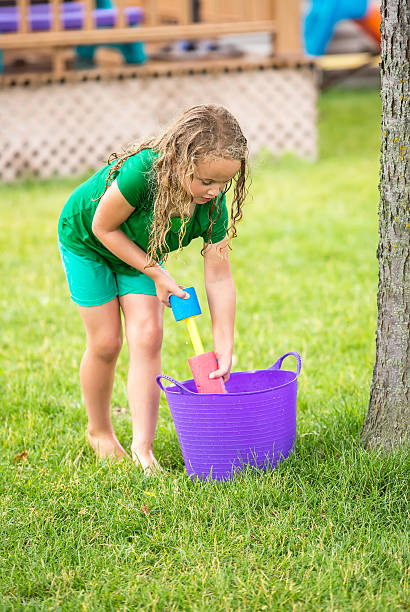 istock Girl Filling Squirter During Water Fight 610693564