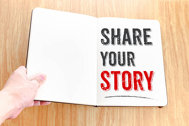 istock Hand holding notebook with Share your story lay on table 610744646