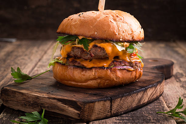 istock Tasty grilled burger with lettuce and mayonnaise , rustic wooden table 610746870
