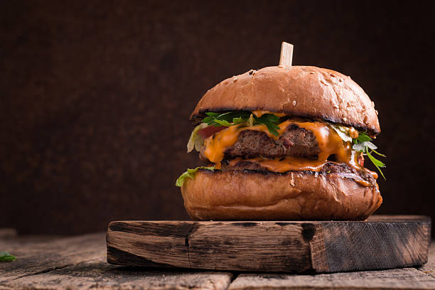 istock Tasty grilled burger with lettuce and mayonnaise , rustic wooden table 610747100