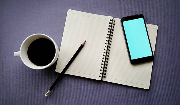 istock Tea in white cup with Journal book and smartphone 610747312