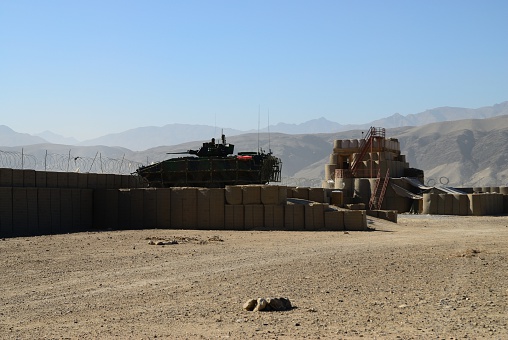 Gwan , Afghanistan - December 11, 2011: View of armored tank at military battlefield by defensive wall.