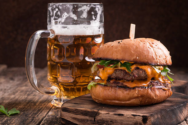 fresh hamburger with a beer on a wooden table. - beer hamburger american culture beef imagens e fotografias de stock