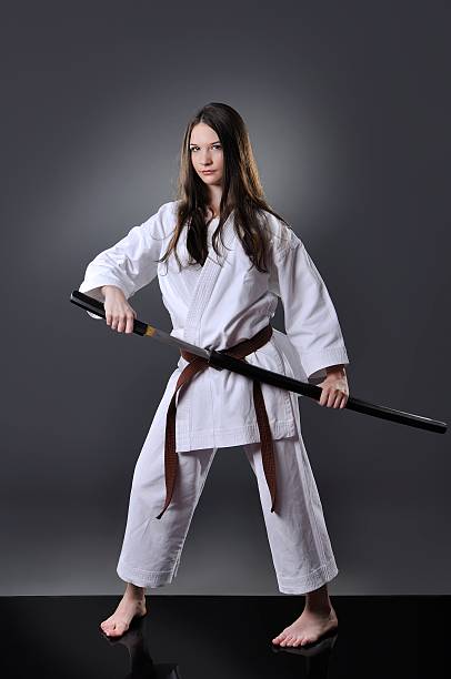 istock Beautiful young brown belt female karate posing with sword 610748360