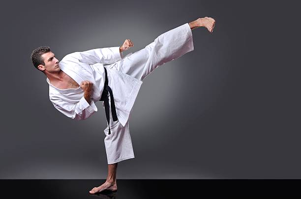 handsome young black belt male karate doing kick - extreme sports karate sport exercising imagens e fotografias de stock