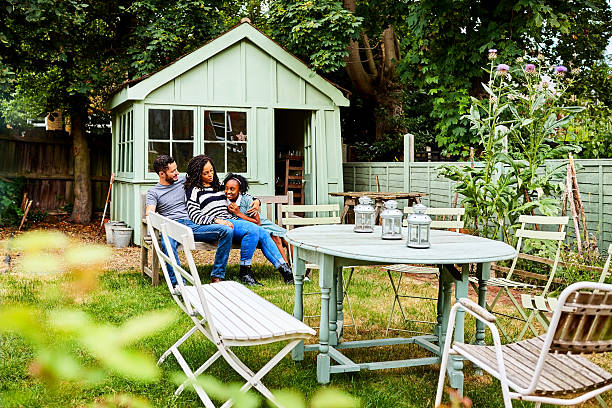 Transgender family sitting together on wooden bench in backyard of their house