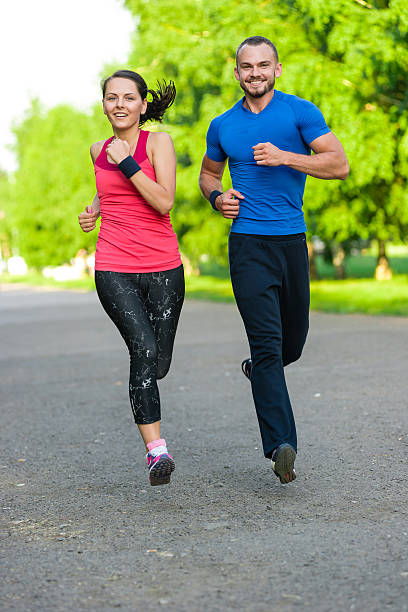 istock Runners training outdoors working out. City running couple jogging outside. 610751536