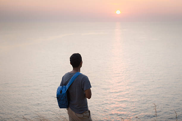 istock solo traveler watching beautiful sunset on the cliff 610753722