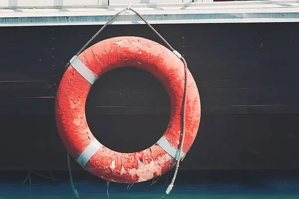 old lifebuoy hanging on a barge outdoor