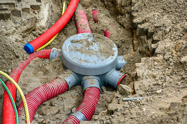 istock Hole in the ground with a node of flexible conduits 610758784