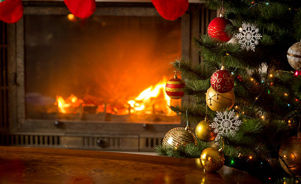 istock Decorated Christmas tree next to burning fireplace 610759164