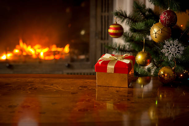 Red gift box on table in front of fireplace
