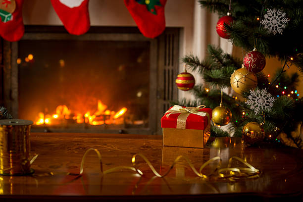 istock Christmas background with gift box on wooden table iat fireplace 610759422