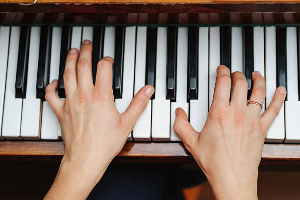 istock woman hands on a piano key 610760078
