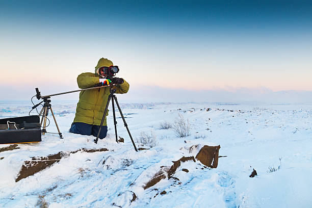 istock Man with photo camera on tripod taking timelapse photos in 610760242
