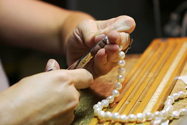 einfädeln einer perlenkette - pearl jewelry necklace women stock-fotos und bilder