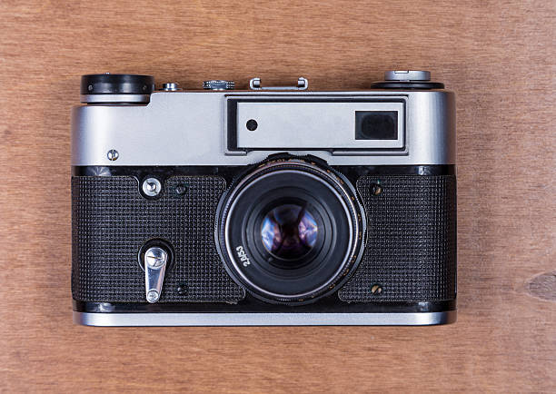istock Retro photo camera on a wooden desk 610763402