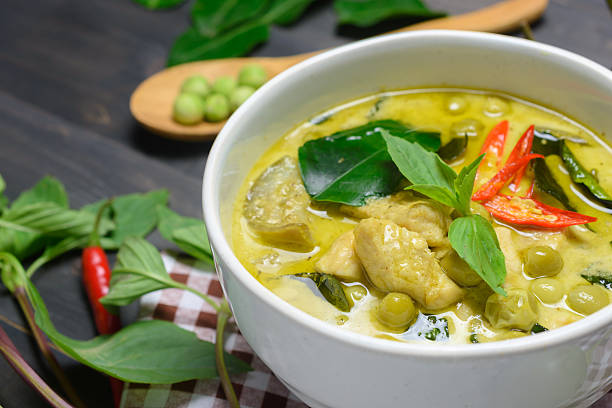 green curry with chicken closeup green curry with chicken (Kang Keaw Wan Gai) with brown tablecloth on wooden background, Thai local food coconut milk photos stock pictures, royalty-free photos & images