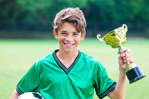 champion de football excité avec trophée - goalie soccer soccer player teenage boys photos et images de collection