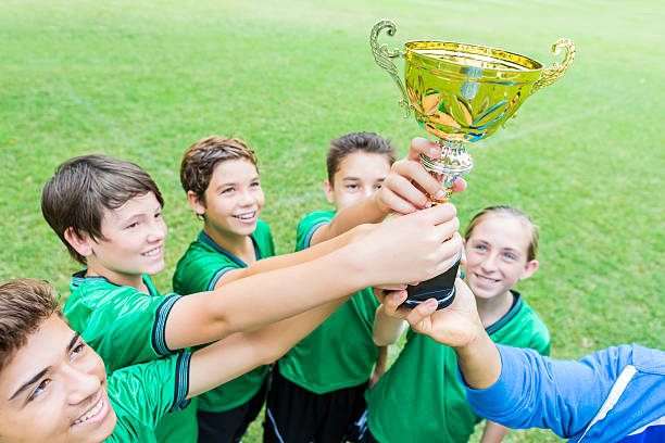 istock Soccer champs hold trophy up high 610765874
