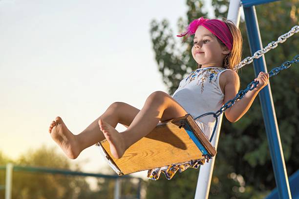 istock Little Girl Swinging At Sun Set 610767276