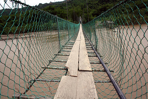 suspension bridge in Malaysia Sabah, Malaysia - July 2, 2011: suspension bridge spanning across murky jungle river in Sabah, Malaysia (Borneo) safety net stock pictures, royalty-free photos & images