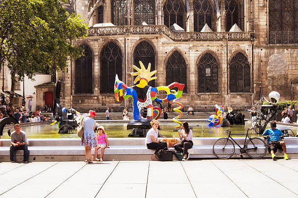 People sit around Stravinsky fountain Paris, France - July 8, 2016: People sit around Stravinsky fountain and enjoy sunny day in Paris. There are many contemporary artworks in the pool. pompidou center stock pictures, royalty-free photos & images