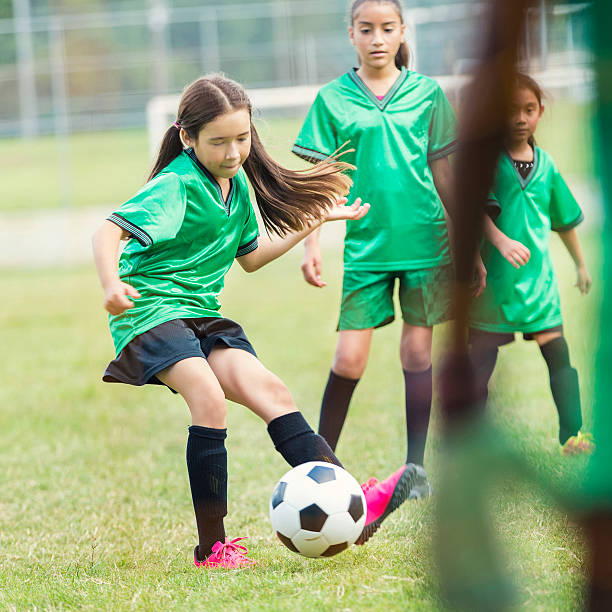 istock Hispanic female athlete kicks soccer ball during game 610771246