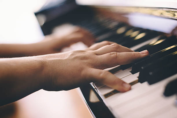 istock Close up of female hands playing piano 610774650