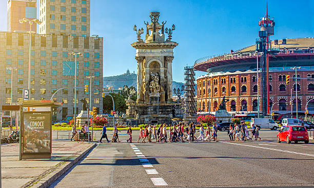 Barcalona, Spain - July 18, 2016: People using sidewalk in Plaza De Espana - Barcelona. Plaza De Espane is one of Barcelona's most important squares, built on the occasion of the 1929 International Exhibition, held at the foot of Montjuic, in the Sants-Montjuic district. There are people in image and they are walking around this big square.