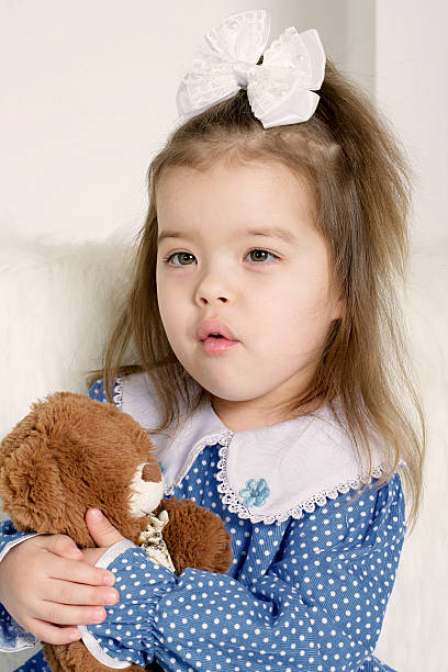 istock Little girl holding a teddy bear 610777170