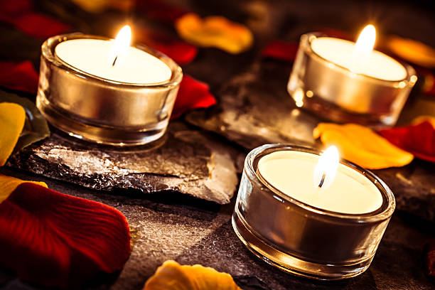 istock Three Romantic Valentine Tealights On Slate With Rose Petals 610779360