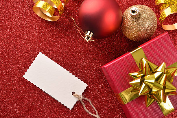istock Xmas decoration with tag gift balls on red table top 610780206