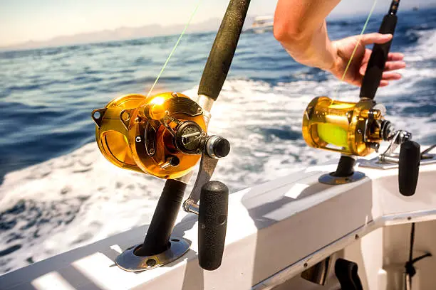 Photo of Ocean Fishing Reels and Rods with Grabbing Hand