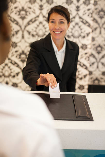istock Female concierge handing room key to guest 610785786