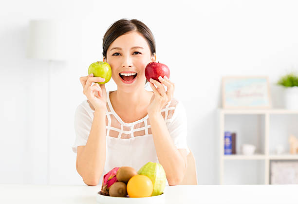 istock young beautiful woman with healthy fruit 610787424