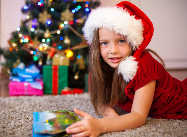 istock Little girl reading at Christmas tree 610787816