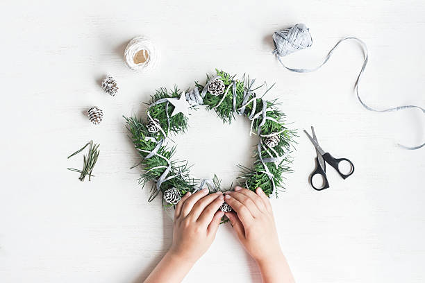 istock Child making handmade christmas wreath. Top view, flat lay 610787912